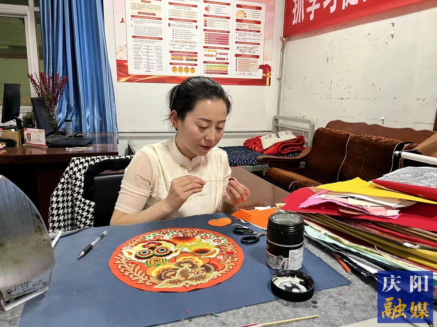 李慶英正在創(chuàng)作布貼畫作品。